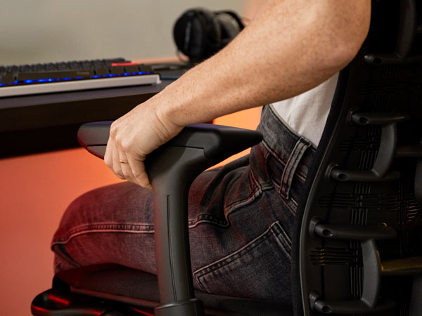 Primer plano de la Dra. Lindsey Migliore ajustando el brazo de la silla gaming Embody