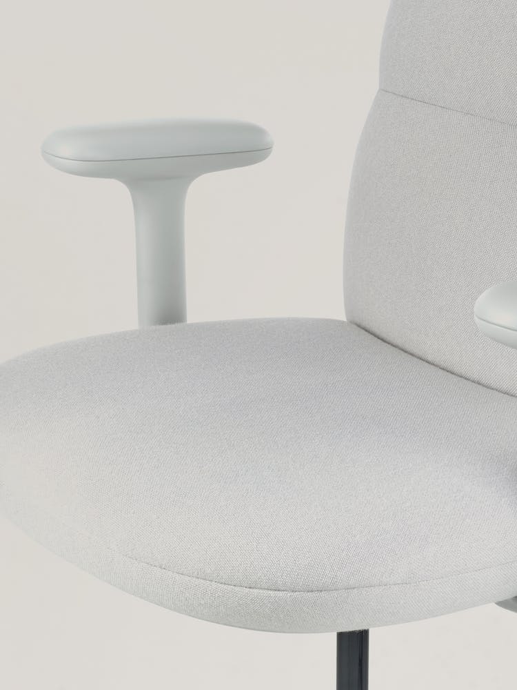 Primer plano de una silla de oficina Asari gris de Herman Miller, mostrando el asiento contorneado.