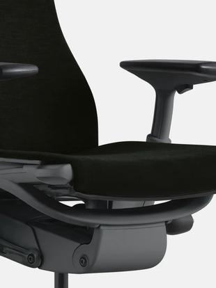 Primer plano de una silla de oficina Embody blanca y azul de Herman Miller, mostrando el contorno del asiento.