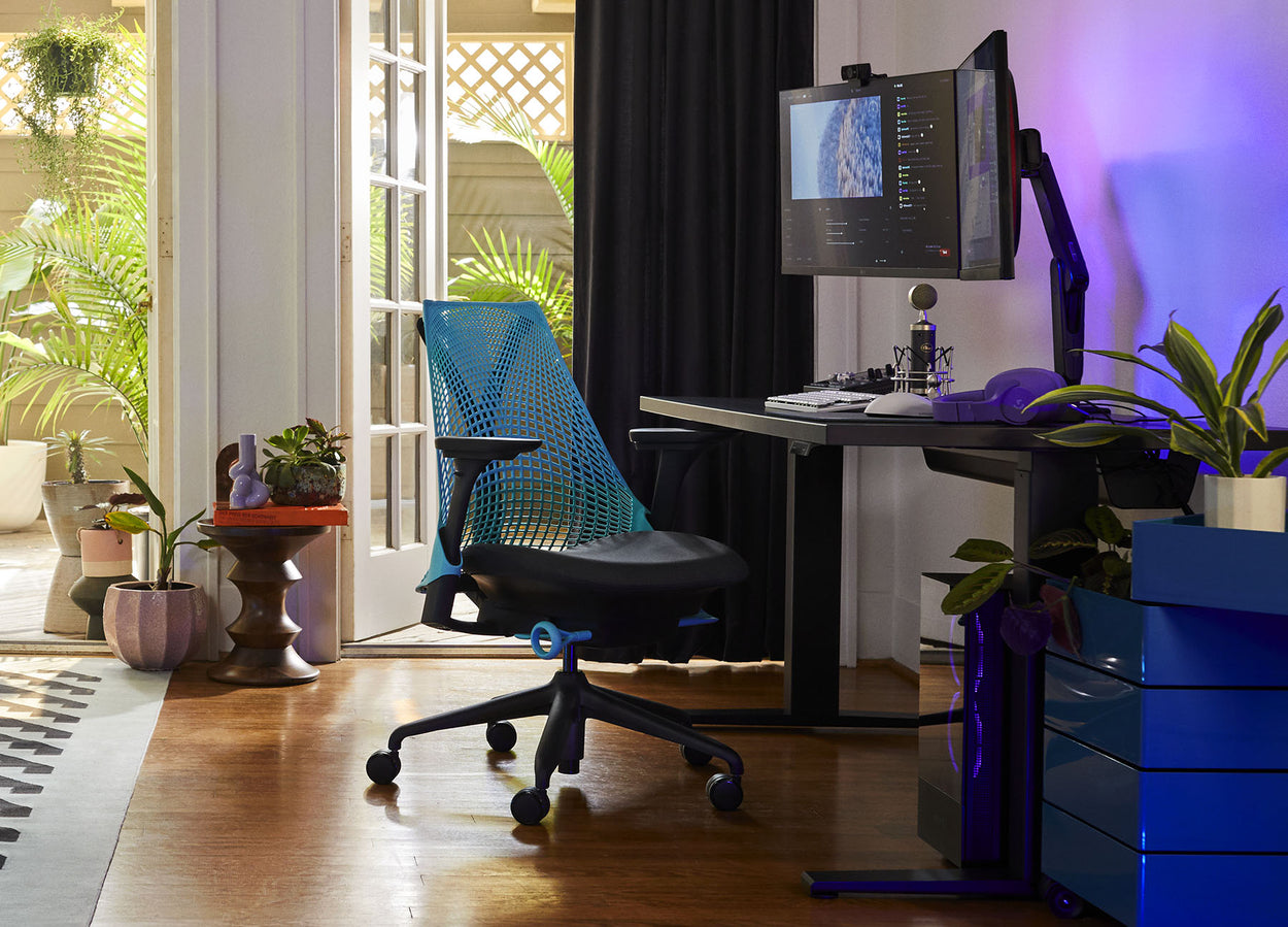 Foto del equipo de gaming de Friskk en su casa, compuesto por una silla gaming Sayl en negro y azul océano con un escritorio gaming Nevi en negro.