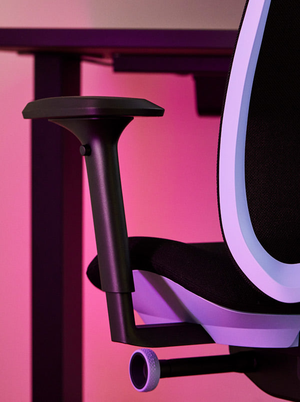 Primer plano de una silla de juego Vantum morada y negra de Herman Miller, mostrando el reposabrazos.