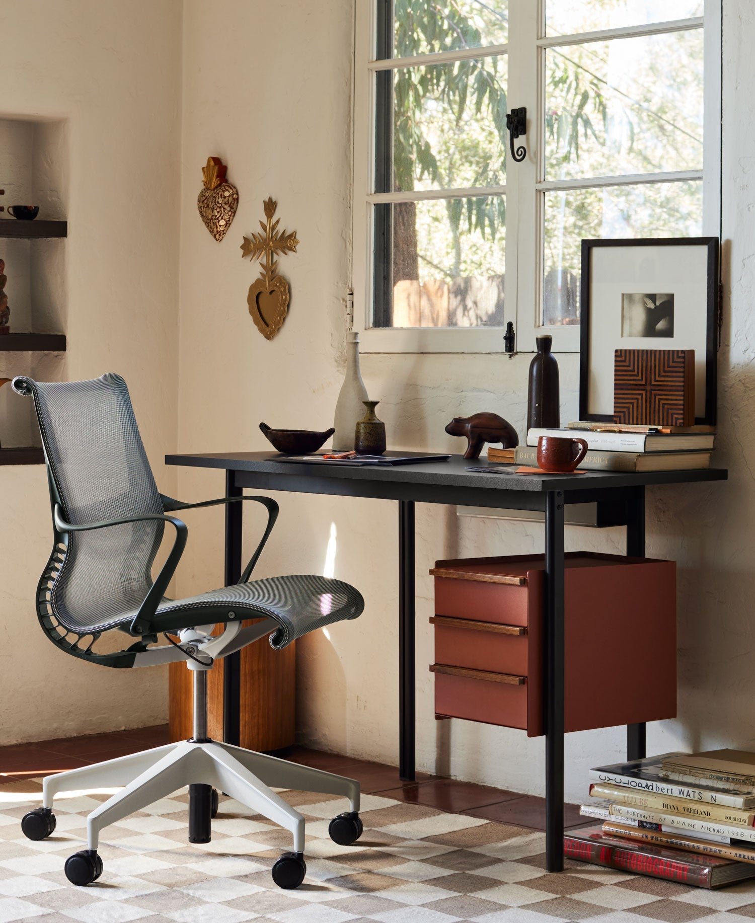 Entorno de oficina en casa con silla de oficina Setu en gris oscuro y escritorio compacto Mode en negro con cajón de almacenamiento.