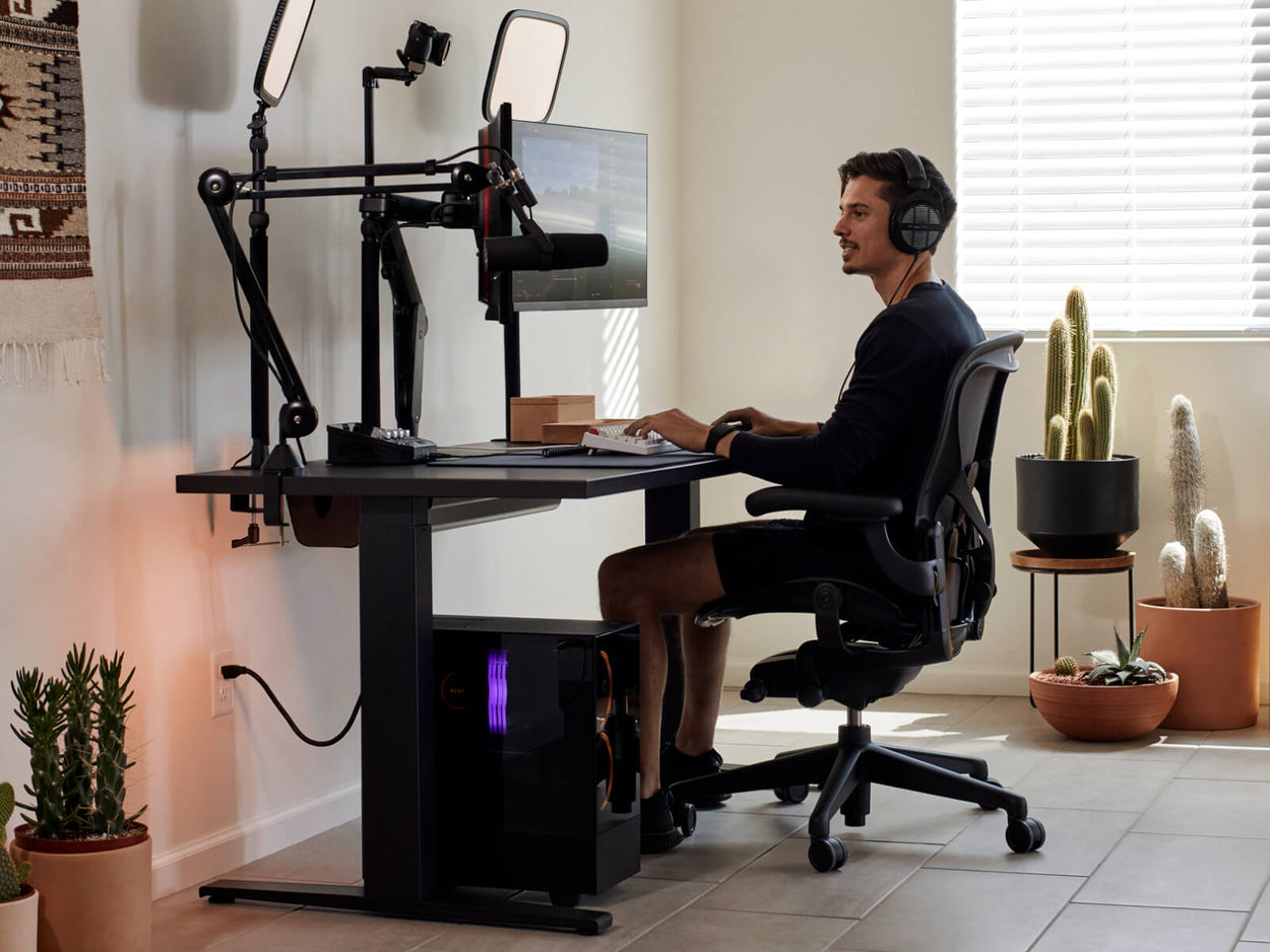 El gamer Xaryu jugando en su equipo Herman Miller, compuesto por una silla gaming Aeron con un escritorio gaming Nevi y brazos para dos monitores Ollin.