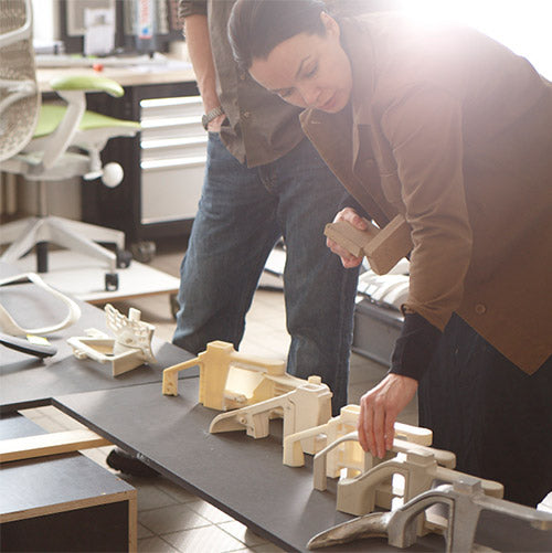 Miembro del equipo de desarrollo de productos de Herman Miller manipulando componentes del prototipo de una silla de oficina.