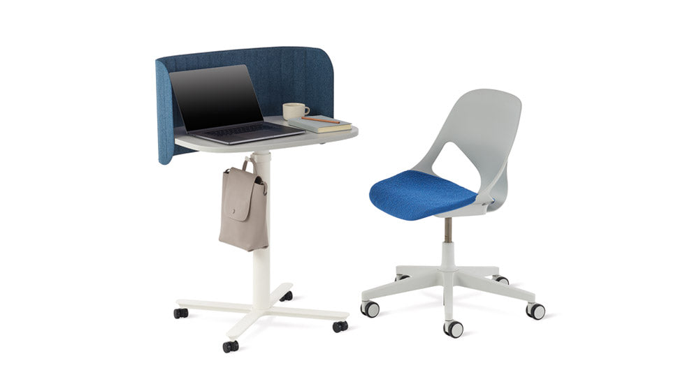 Una mesa de trabajo Passport blanca de Herman Miller con una pantalla de escritorio Passport azul. Colocada junto a una silla de oficina Zeph gris y azul.
