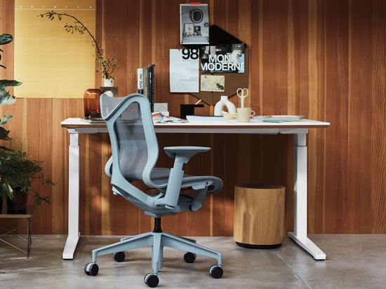 Escritorio en casa con silla Cosm de respaldo bajo en color gris glaciar y mesa sit-stand Nevi en blanco.