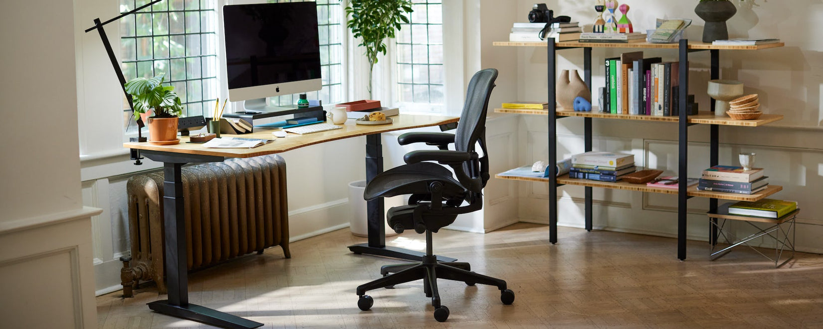 Oficina en casa con la icónica silla Herman Miller Aeron en negro ónix con escritorio Jarvis con patas y tablero contorneado de bambú.