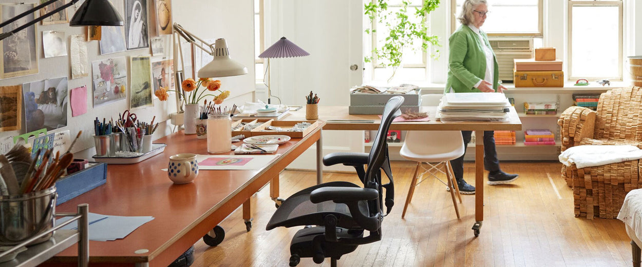 Foto del estudio de la artista Maira Kalman con una silla de oficina Aeron en grafito y una lámpara de mesa Hay Matin.