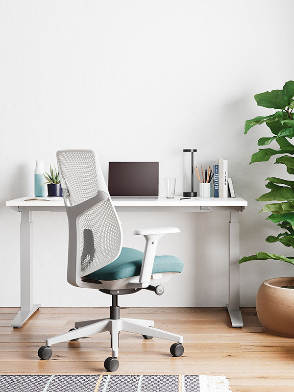 Silla de oficina para el hogar Verus en blanco y azul pálido delante de un escritorio blanco Nevi para trabajar sentado o de pie