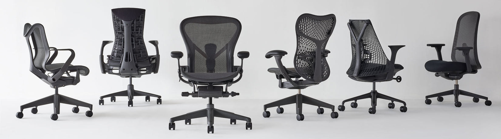 Alineación de sillas de oficina para el hogar de Herman Miller en diferentes ángulos, todas en grafito, con respaldo bajo Cosm, Aeron, Mirra 2 y Lino