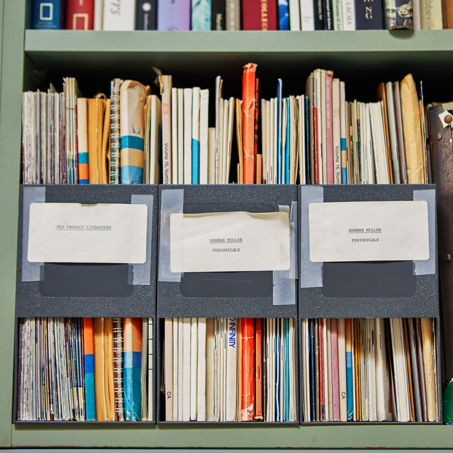 Imagen de una estantería con archivos de diseño e investigación relacionados con el diseño y el desarrollo de productos de Herman Miller